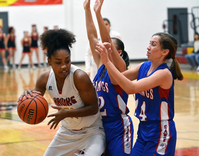Centennial's Iysis Briggs tries to back into the lane as Las Cruces High's Alexia Gonzalez (12) and Christina Aguayo (14) put on the pressure.