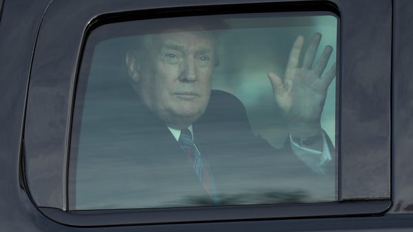President Donald Trump waves from his vehicle as...
