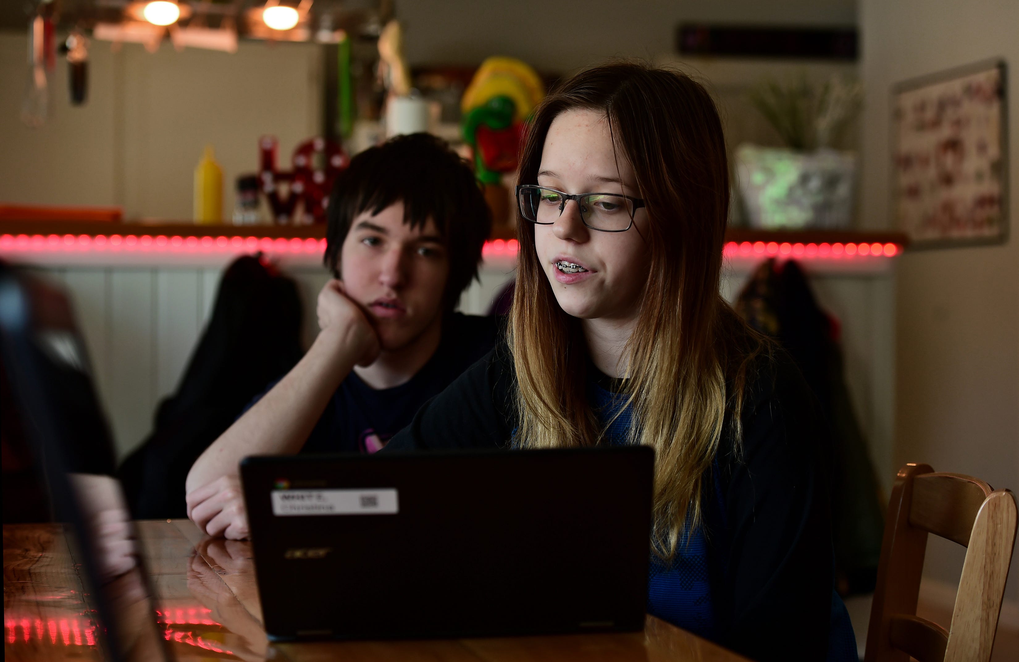 Bradford student Christina White, 17, works on her school-issued computer as her brother Damien White, 16, looks on in the family's home in rural Steuben County, NY.  January 28, 2019.