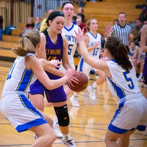 Jenna Hornblad and Hallie Wusterbarth apply pressure to Sara Dax of Kewaunee as she drives to the basket on a fast break in their game on Friday.