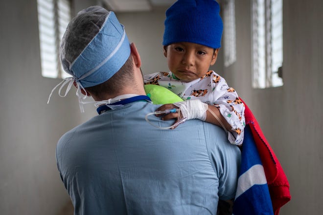 Fernando Damien Ixocopal Garcia, 5, is carried by COTA PACU nurse James Smith of Philadelphia to the children’s recovery area following his surgery. Jan. 21, 2019