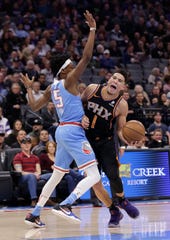Phoenix Suns guard Devin Booker, right, is fouled by Sacramento Kings guard De'Aaron Fox, left, as he drives to the basket against during the first half of an NBA basketball game Sunday, Feb. 10, 2019, in Sacramento, Calif.