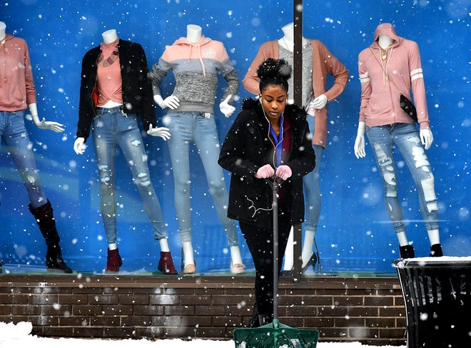 Rainbow Shops Junior Manager Adrianna Fritz shovels snow outside the store's spring fashion window display on West Market Street in York City Monday, Feb. 11, 2019. Forecasters say a mix of sleet, snow and rain is on tap for the area into Tuesday. Bill Kalina photo