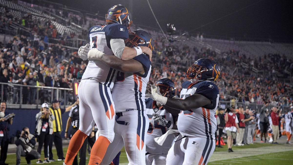 Orlando Apollos quarterback Garrett Gilbert, left, is congratulated by teammates after catching a pass from receiver Jalin Marshall for a 5-yard touchdown during the first half of an Alliance of American Ffootball game against the Atlanta Legends .
