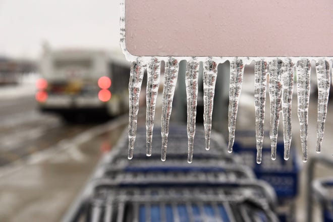 Icicles hang on a shopping cart return sign at the Meijer superstore along 8 Mile Road in Detroit on Tuesday, February 12, 2019.