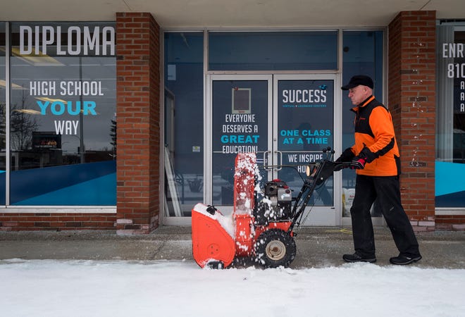 Mike Glombowski, owner of Mike Glombowski Snow Handling, uses a snowblower to clear a sidewalk Tuesday, Feb. 12, 2019 in downtown Port Huron. 