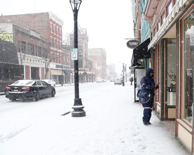 Lisa Andino, letter carrier for the United States Postal Service, delivers mail on Main Street in Poughkeepsie, New York, on Feb. 12, 2019.