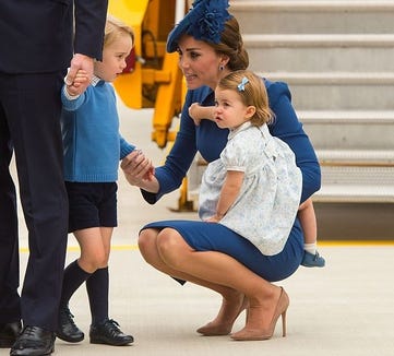 The Duchess of Cambridge showing her parenting technique with Prince George while holding Princess Charlotte.