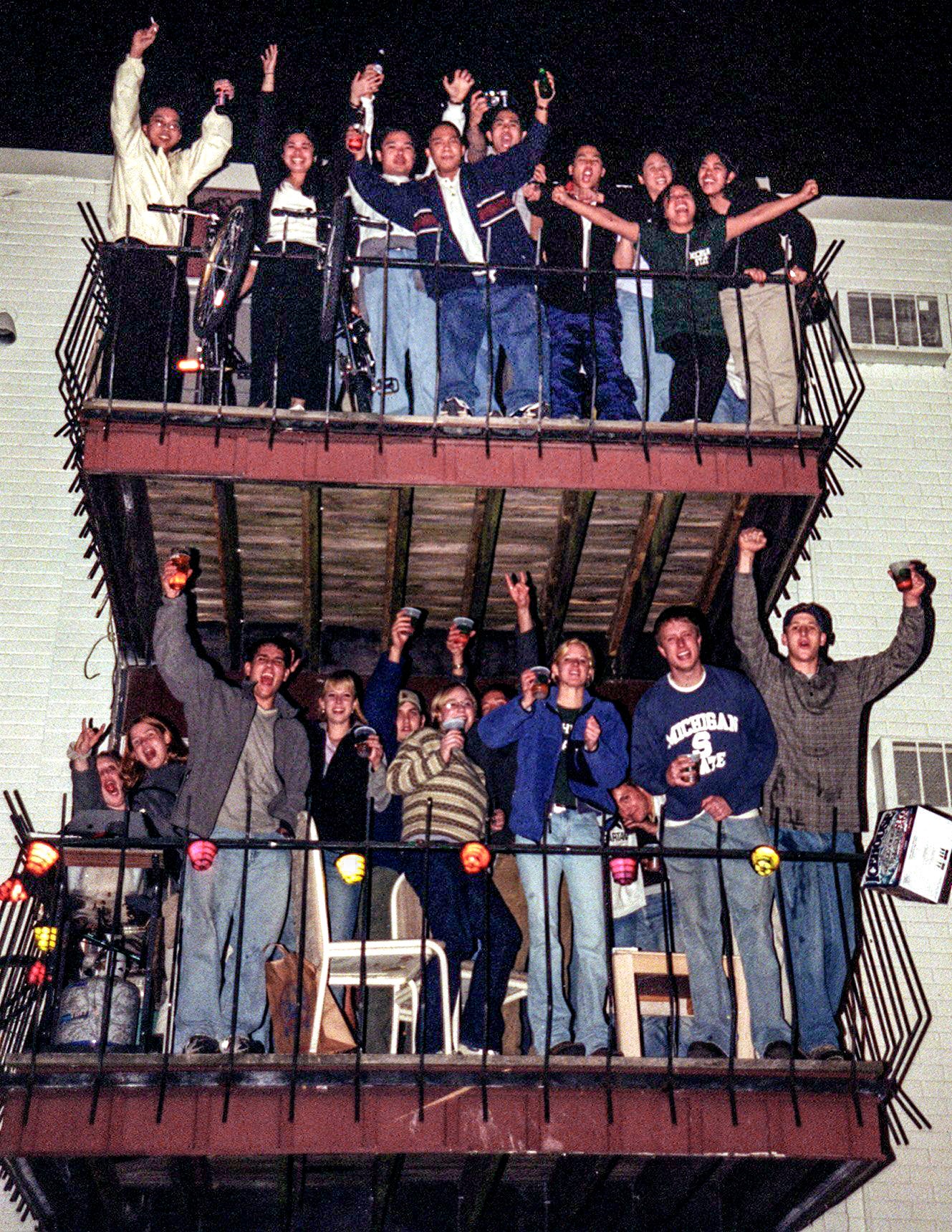 Cedar Village residents celebrate at half-time of the Final Four game between Michigan State University and Duke in the NCAA Men's Basketball Tournament  on Saturday, March 27, 1999, in East Lansing. MSU lost the game, triggering bonfires and riots in the city.
