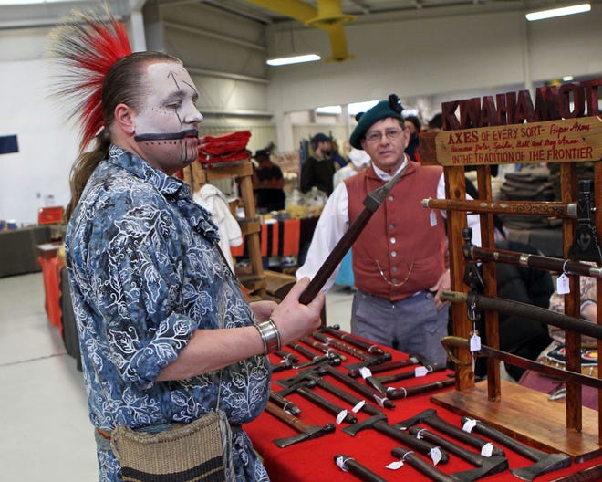 Daniel Youngbauer of Oshkosh, dressed in traditional Meskwaki Indian face paint, checks out the tomahawks at the Echoes of the Past historical trade fair in 2018.