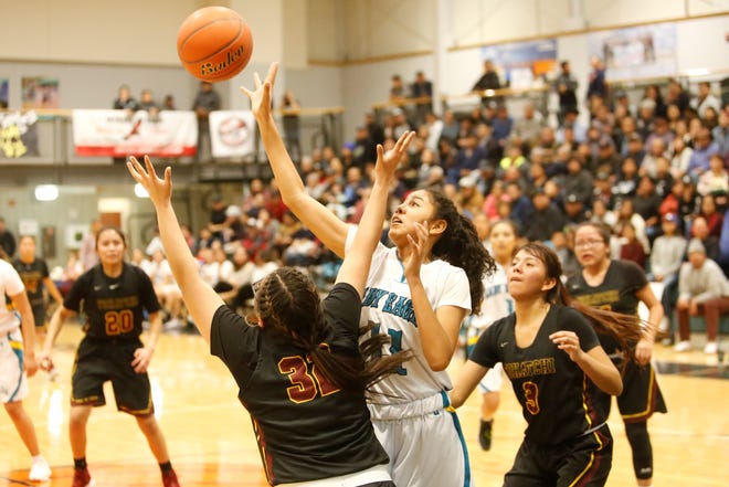 Navajo Prep's Hailey Martin tips the ball back out to the right edge of the wing against Tohatchi's Gabrielle Thomas (32) during Tuesday's District 1-3A game at the Eagles Nest in Farmington. Prep is No. 6 in this week's NMOTSC 3A girls rankings.