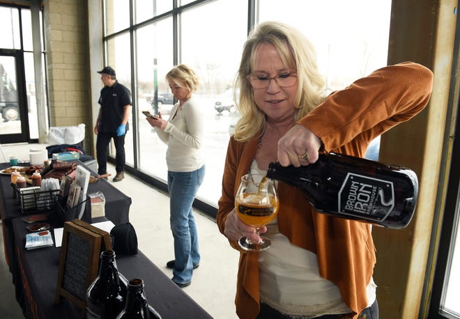 Patti Eisenbraun, Co-owner of Brown Iron Brewhouse in Washington Township, pours a glass of beer during the press event. Brown Iron Brewhouse will be one of the new retailers in the Woodward Corners by Beaumont development.