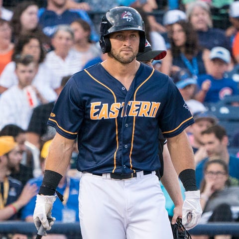 Tim Tebow shown picking up a bat at the end of...