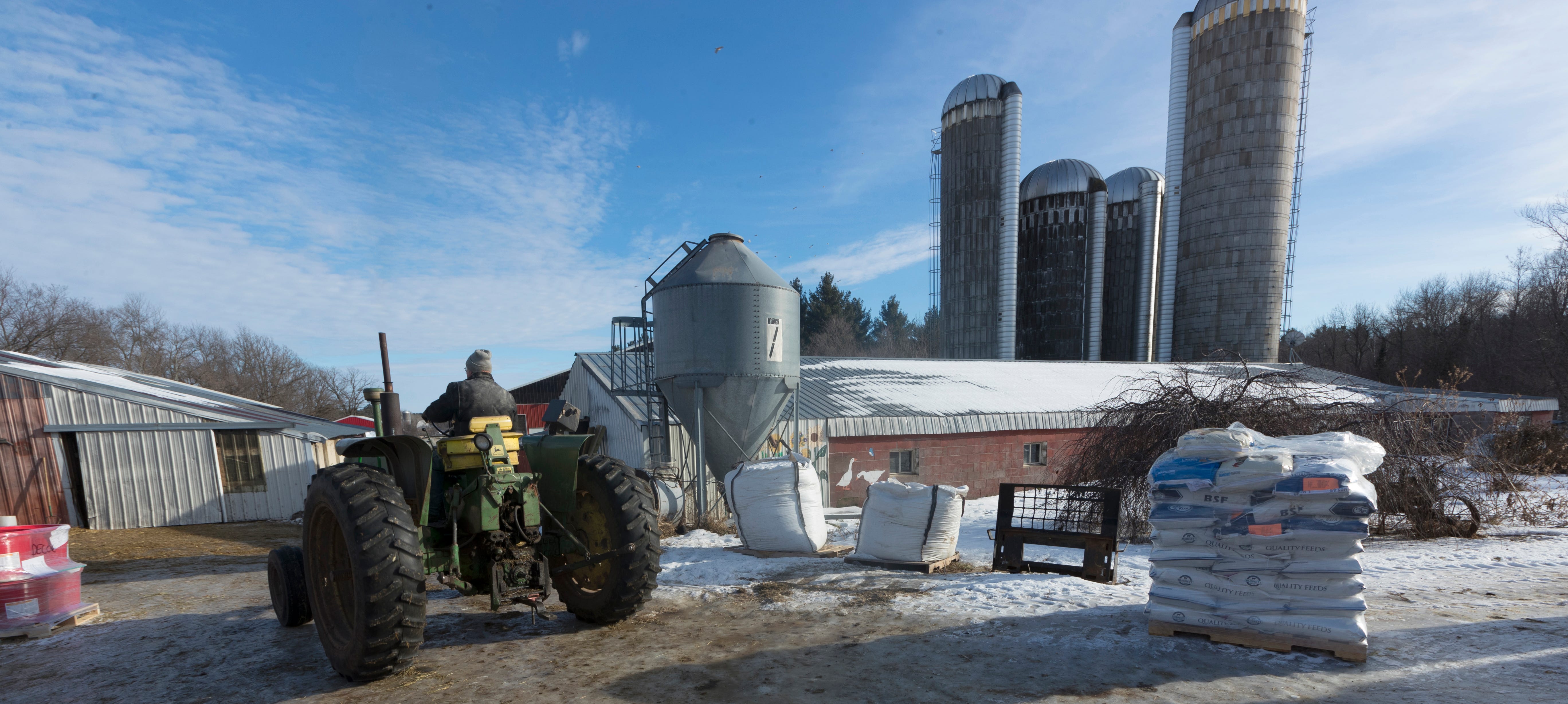 Chuck Spaulding moves his 1964 John Deere tractor into a shed while doing chores on their farm in Shell Lake.