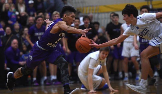 Reed's Trey Stevens (10) and Spanish Springs' Leo Grass reach for a loose ball during their basketball game in Sparks on Feb. 16, 2019.