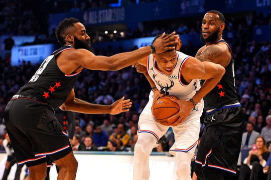 Giannis Antetokounmpo tries to divide the defense of James Harden and LeBron James in the NBA 2019 All-Star Game.