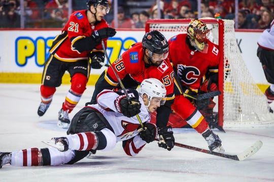 Feb 18, 2019: Arizona Coyotes right wing Josh Archibald (45) and Calgary Flames defenseman Oliver Kylington (58) battle for the puck during the second period at Scotiabank Saddledome.