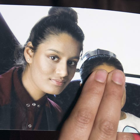 A family member of Shamima Begum holds a picture...