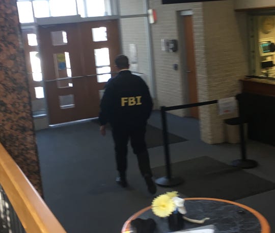 An FBI agent takes part in a raid at Taylor City Hall on Tuesday, Feb. 19, 2019.