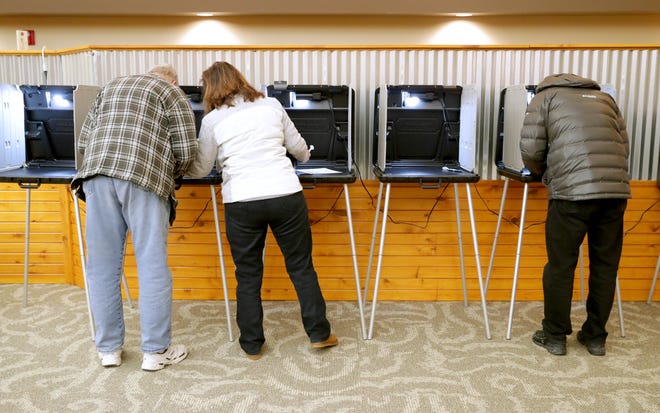 Bob Lemke, left, is assisted by his wife, Cheryl Lemke, as they vote at the Pieper Power Education Center voting location at the Mequon Nature Preserve.