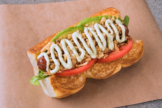 Wild arugula, avocado, tomato, crispy onions and spicy basil aioli adorn the Sooo-Cali hot dog at Dog Haus.