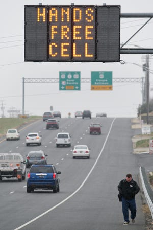 Minnesota would become one of 18 states plus the District of Columbia that require drivers to use hands-free devices while phoning. This sign is in Delaware, which passed a hands-free cell phone law in 2010.