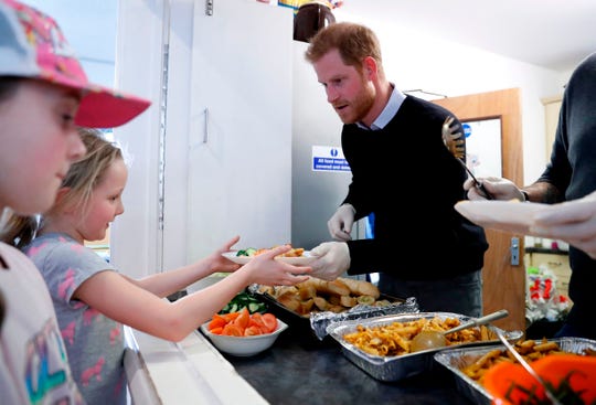 Prince Harry helps serve hot lunches when he visits a Fit and Fed program in London on February 19, 2019. The project features activity sessions and a nutritious daily meal for local children.