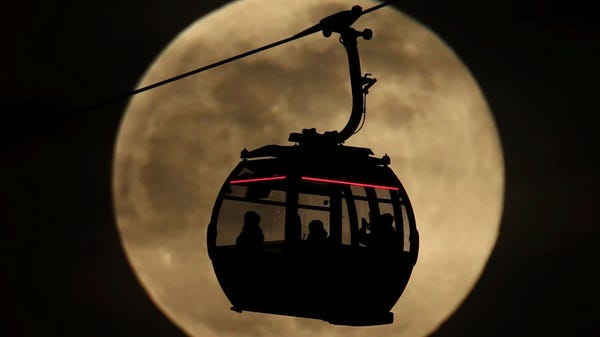 An Emirates Air Line cable cars is silhouetted...