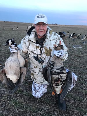 Roger Lydeen holds some of the day's harvest during a late season goose hunt to Kansas.