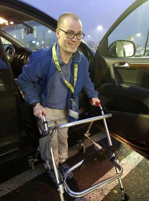 In this Dec. 14, 2018 photo provided by Holly Catlin, Adam Catlin gets out of a car before starting his shift at a Walmart in Selinsgrove, Pa. Catlin, who has cerebral palsy, is afraid heâ€™ll be out of work after store officials changed his job description to add tasks that heâ€™s physically unable to do. (Holly Catlin via AP)