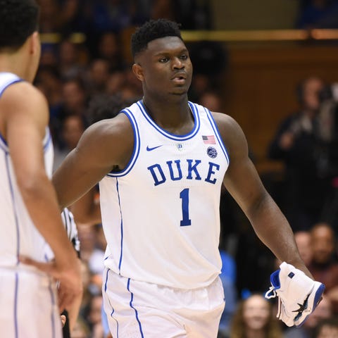 Zion Williamson walks off the court while holding...