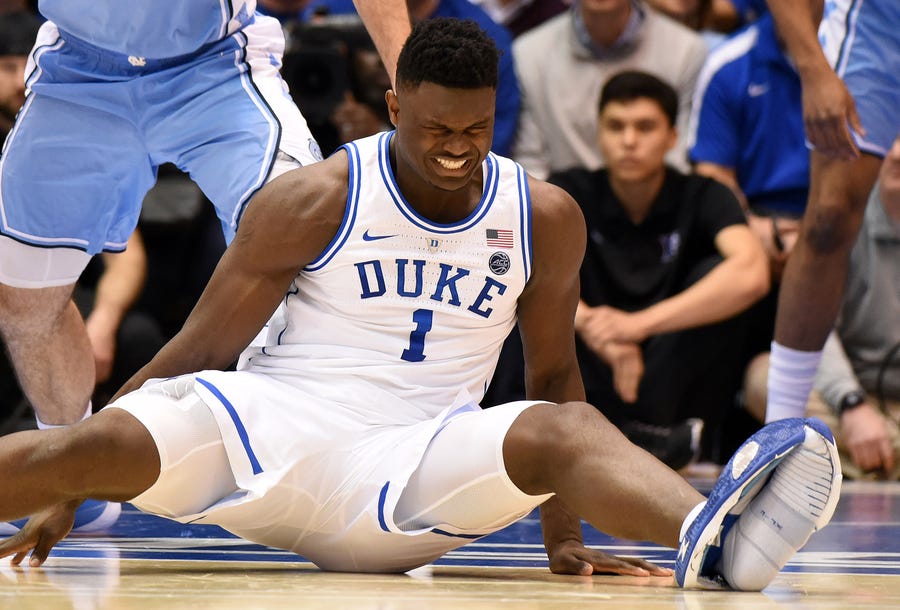 Duke Blue Devils forward Zion Williamson  reacts after his shoe gave way during a game against North Carolina.
