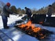 Kris Bloedow (from left), Bill Jessen and Ben Bloedow light a bed of charcoal that will burn overnight and thaw the ground at a grave in Avoca Cemetery. They will dig the grave by hand the following day. Frost at the cemetery, located in Iowa County near the Wisconsin River, was about 20 inches deep.