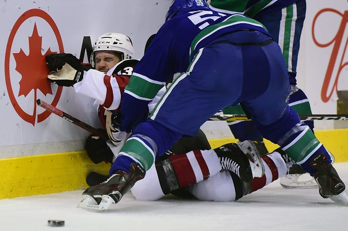 Feb 21, 2019; Vancouver, British Columbia, CAN; Vancouver Canucks defenseman Alex Biega (55) checks Arizona Coyotes forward Vinnie Hinostroza (13) during the second period at Rogers Arena. Mandatory Credit: Anne-Marie Sorvin-USA TODAY Sports