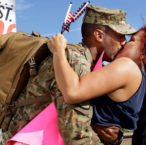 Army Corp. Edwin Liriano, left, kisses his wife,...