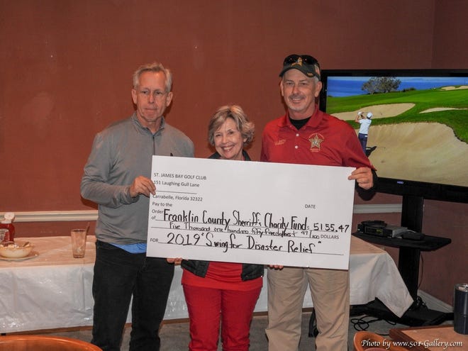 John Green of St James Bay Golf Club and Betty Kellum present Sheriff AJ Smith with a check for $5,155.47.