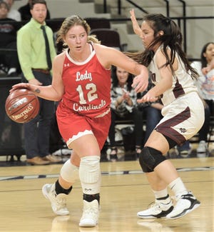 Hermleigh's Sandra Carr (12) dribbles around a Rankin defender in the Region II-1A championship game last weekend at ACU's Moody Coliseum. The Lady Cardinals return to the state tournament, playing Nazareth on Thursday morning in San Antonio.