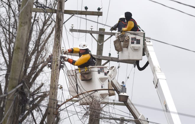 DTE line crews repair a power line along Caniff Street near Oakland Street in Detroit on Sunday, February 24, 2019 as high winds caused power outages in the area.