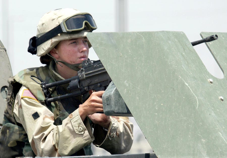 A female soldier mans a machine gun on a vehicle during clashes in the northern Iraqi city of Mosul in 2003. On Friday, a federal judge in Texas ruled that now that combat roles are available to women, a male-only draft is unconstitutional.