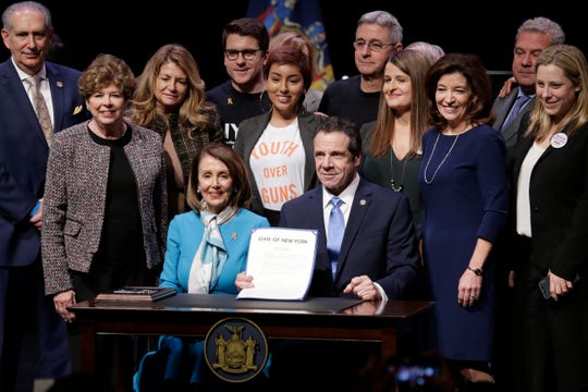 House Speaker Nancy Pelosi, center left, joins New York Governor Andrew Cuomo, center right, as they pose for a picture after signing a gun control bill at a ceremony in New York, Monday, Feb. 25, 2019. Cuomo signed a "red flag" bill, which attempts to prevent people who present a threat to themselves or others from purchasing or owning a gun.