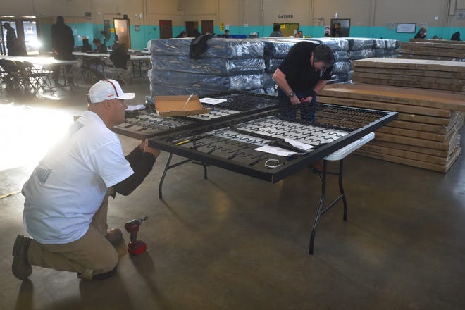Cisco Carreno, left, and Manley McNinch, of Local 805 Southwest Regional Council of Carpenters, joined dozens of union members to assemble 100 beds at the west county regional homeless shelter in Oxnard on Monday. The beds were paid for largely through donations from area cannabis dispensaries.