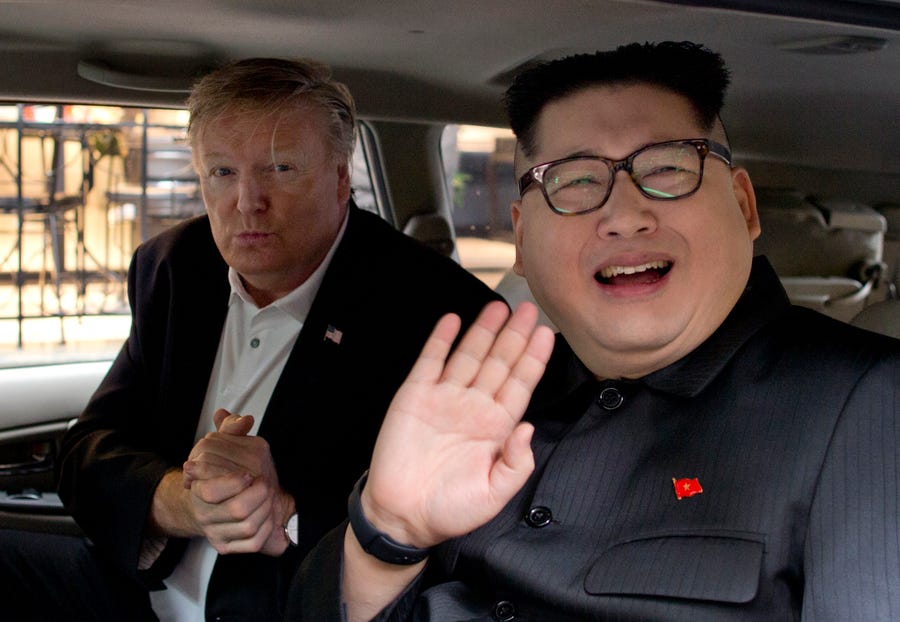 Howard X, right, a Kim Jong Un impersonator, waves as Russel White, a President Donald Trump impersonator, gestures from a car outside La Paix hotel in Hanoi, Vietnam, on Monday.