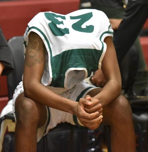 Cass Tech's Christopher Jones covers his head with his jersey after his team's loss to Detroit King in double-overtime.