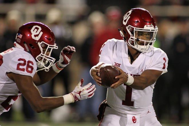 Oklahoma quarterback Kyler Murray (1) gets set to hand the ball off to running back Kennedy Brooks (26) during a game against Texas Tech.
