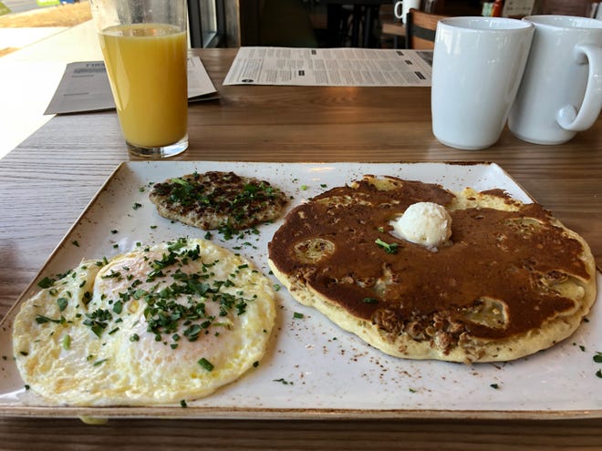 The Tri-fecta at First Watch features two fresh cage-free eggs any style (seen over easy here), an airy Belgian waffle or multigrain pancake (banana crunch pancake pictured) and choice of bacon, savory chicken sausage patty (pictured), turkey or pork sausage link.