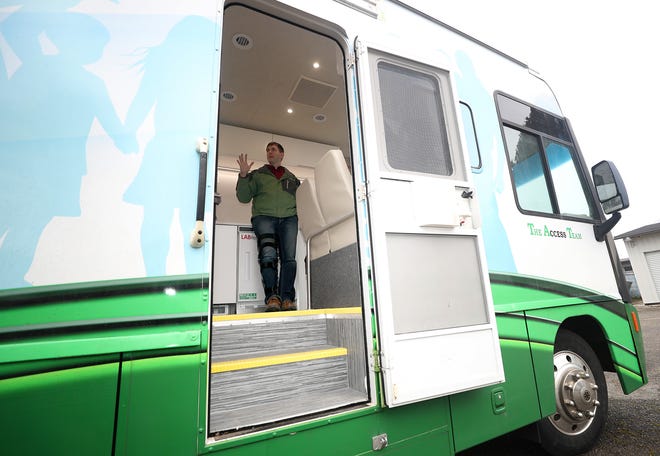 Peninsula Community Health's associate medical director, Anthony Lyon-Loftus, is framed in the doorway of its new mobile primary care unit. PCHS has introduced the clinic on wheels to Kitsap County, serving patients who can't make it into a brick-and-mortar clinic.