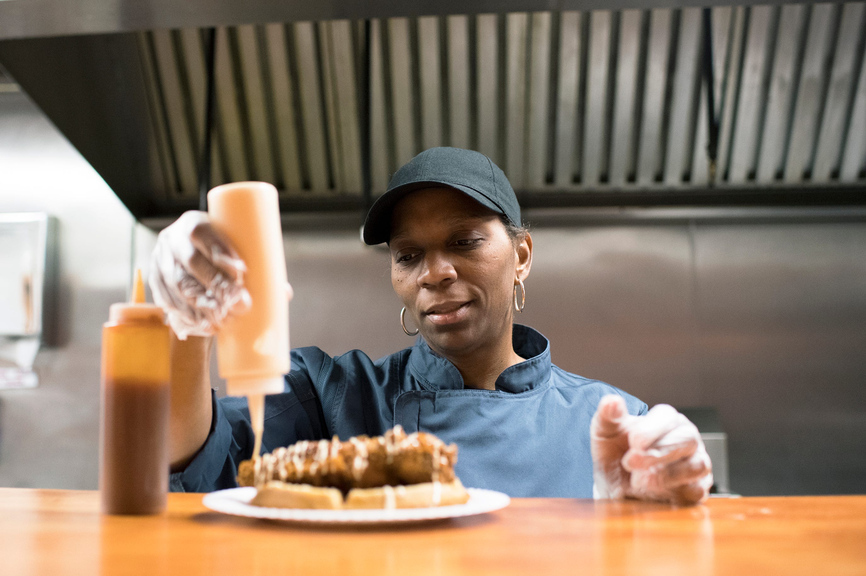 Nancy Miller, chef and owner of Taste of SOUL in Burlington City, N.J., prepares a chicken and sweet potato waffle dish. She's adding the French vanilla cream to the popular dish.