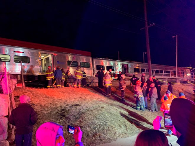 First responders work the scene of a collision involving a Manhattan-bound commuter train and a vehicle in Westbury, N.Y., Tuesday, Feb. 26, 2019. The Long Island Rail Road says service was suspended Tuesday evening in both directions on the Ronkonkoma and Huntington/Port Jefferson branches. (Howard Schnapp/Newsday via AP)