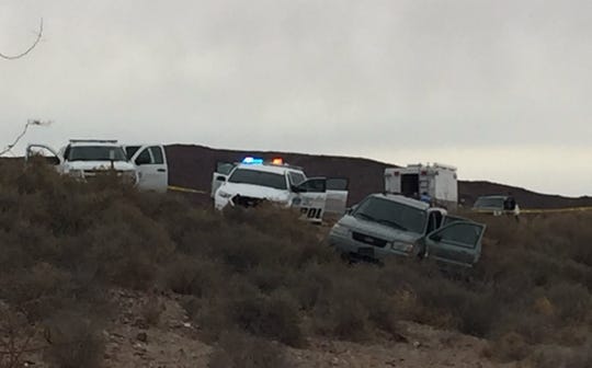 New Mexico State Police and other agencies investigate following an officer-involved shooting along Interstate 25 north of Las Cruces. The suspect was shot while allegedly barricaded inside the green Ford Escape at the forefront of the photo.