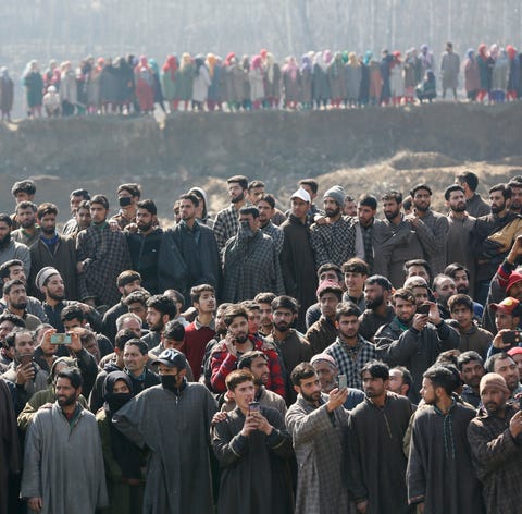 Kashmiri villagers gather to look at  the...